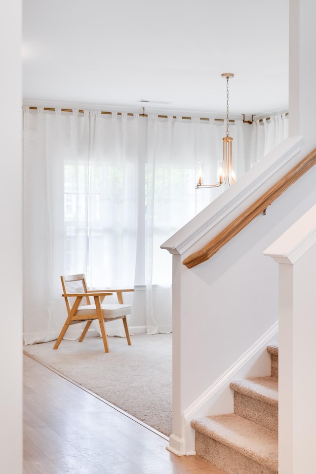 stairway with an inviting chandelier, carpet, and baseboards
