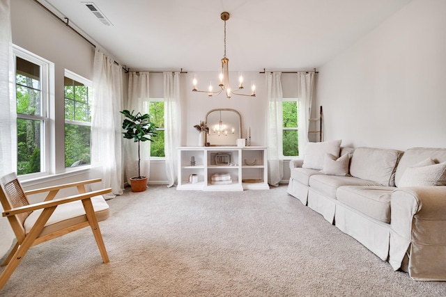 living area with a wealth of natural light, visible vents, a notable chandelier, and carpet floors