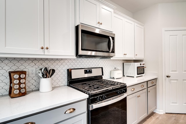 kitchen featuring appliances with stainless steel finishes, light countertops, and decorative backsplash