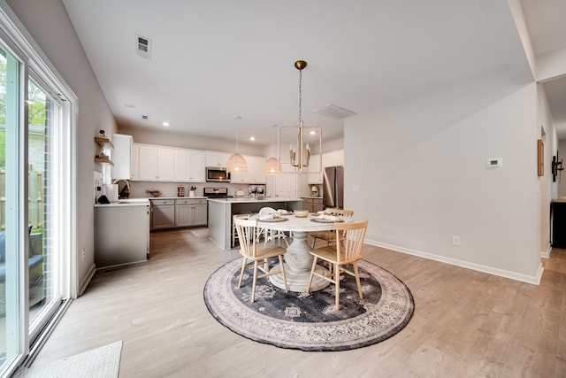 dining room with baseboards, visible vents, light wood-style floors, and recessed lighting