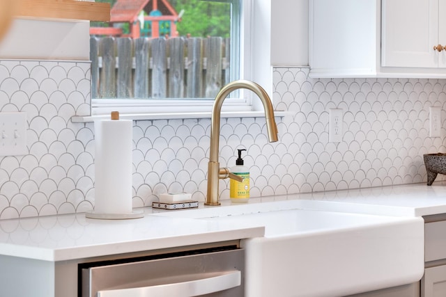 room details with white cabinetry, a sink, light countertops, dishwasher, and backsplash