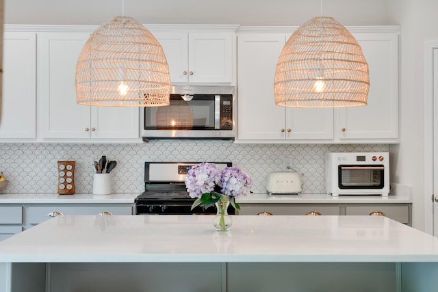 kitchen with light countertops, white cabinetry, stainless steel appliances, and decorative backsplash