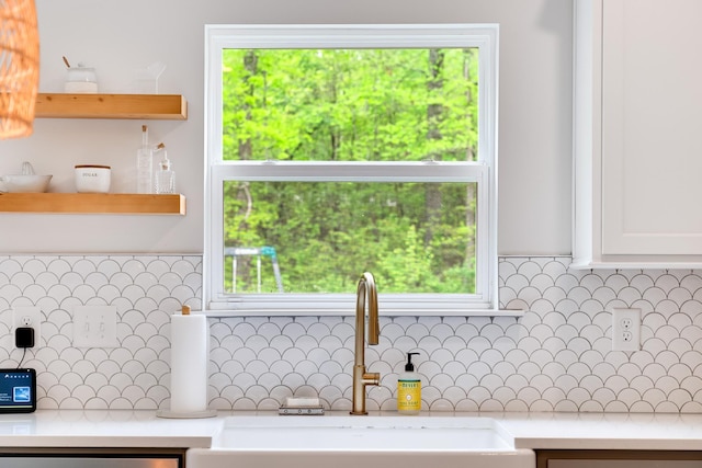 room details featuring a sink, decorative backsplash, open shelves, white cabinetry, and light countertops