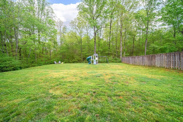 view of yard featuring fence and a playground