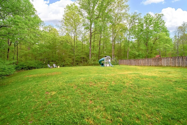 view of yard featuring fence and a playground