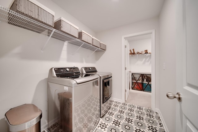 washroom with washing machine and clothes dryer, laundry area, and baseboards