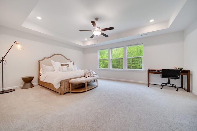 carpeted bedroom featuring baseboards, recessed lighting, ceiling fan, and a tray ceiling