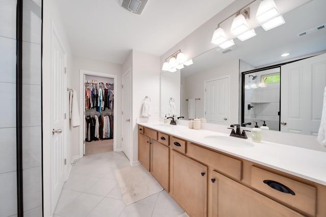 bathroom with double vanity, visible vents, a stall shower, and a sink