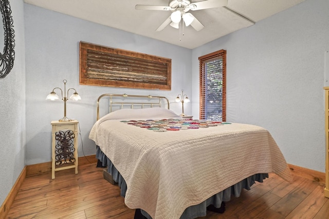 bedroom with hardwood / wood-style floors, baseboards, and ceiling fan