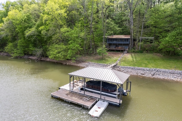 view of dock with a lawn, a forest view, boat lift, and a water view