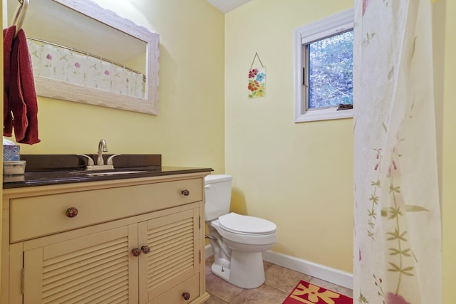 bathroom featuring baseboards, toilet, vanity, and tile patterned floors