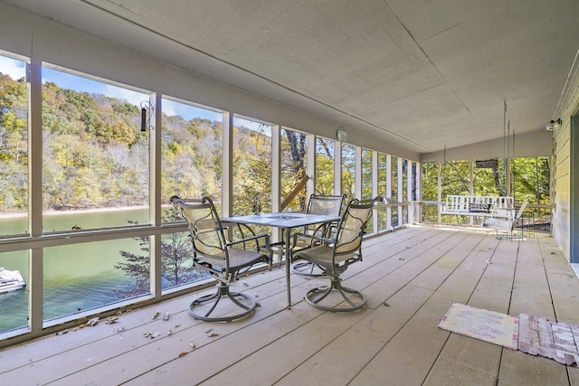 sunroom featuring a water view
