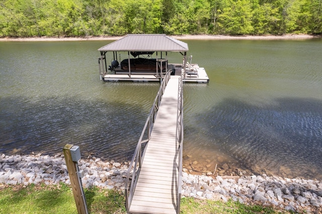 view of dock with a view of trees, boat lift, and a water view