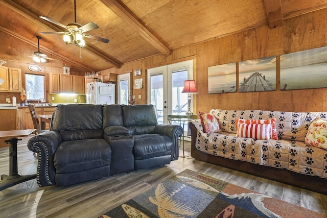 living room featuring wood finished floors, lofted ceiling with beams, wooden walls, wood ceiling, and ceiling fan