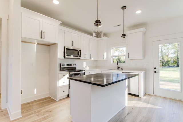 kitchen with stainless steel appliances, a sink, light wood-style floors, and a wealth of natural light