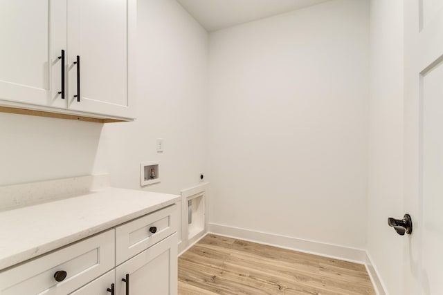 washroom with light wood finished floors, baseboards, washer hookup, cabinet space, and electric dryer hookup