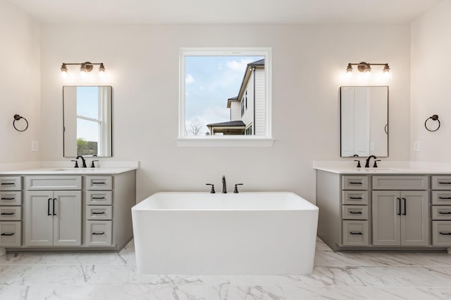 7408 Black Fox Dr, Fairview, TN 37062 - bathroom featuring two vanities, a freestanding tub, marble finish floor, and a sink