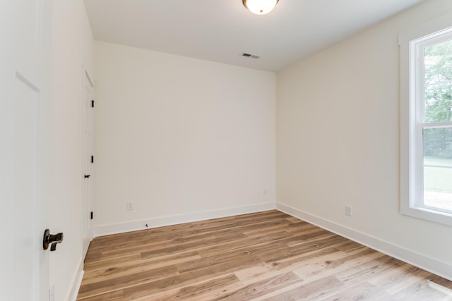 unfurnished room featuring baseboards and light wood-style floors