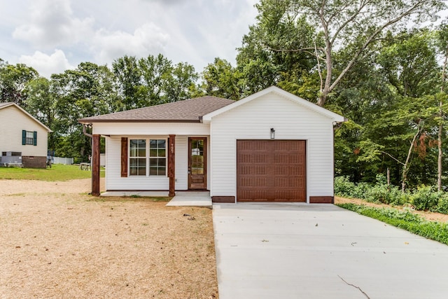 single story home with driveway, covered porch, a shingled roof, and a garage