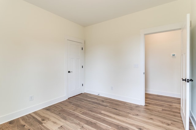 empty room featuring baseboards and light wood-style floors