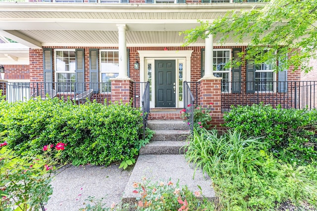 property entrance with brick siding and a porch