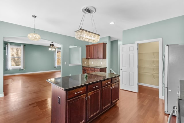 kitchen with freestanding refrigerator, dark wood finished floors, baseboards, and a ceiling fan