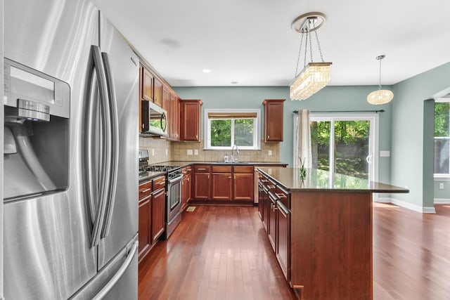 kitchen featuring appliances with stainless steel finishes, a sink, dark wood-style floors, decorative backsplash, and recessed lighting