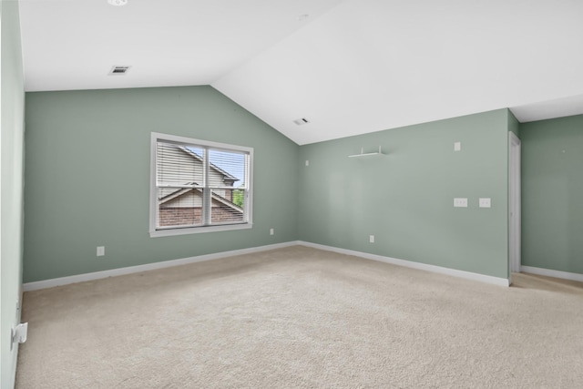 carpeted empty room with lofted ceiling and baseboards