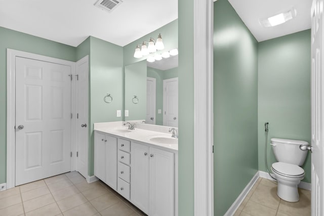 bathroom with tile patterned flooring, baseboards, toilet, and double vanity