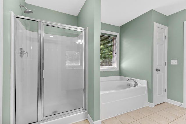 bathroom featuring a shower stall, a bath, tile patterned floors, and baseboards