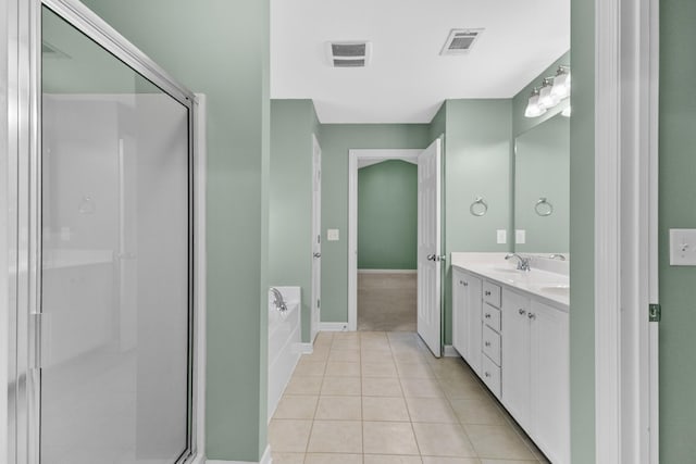 bathroom featuring tile patterned floors, a garden tub, a stall shower, double vanity, and baseboards