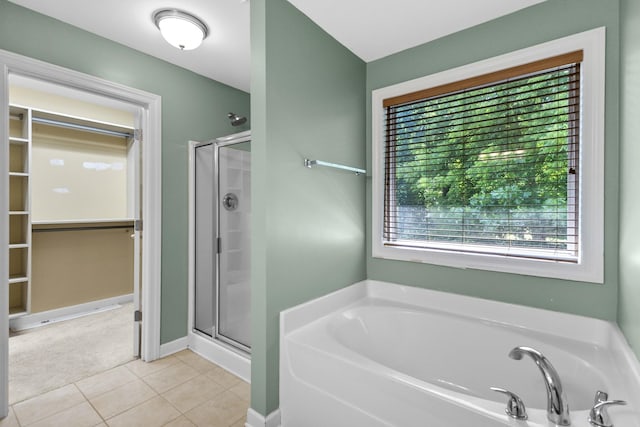 full bath with a shower stall, a bath, tile patterned floors, and a spacious closet