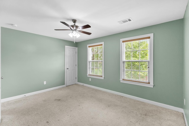 empty room with baseboards, ceiling fan, carpet floors, and a smoke detector