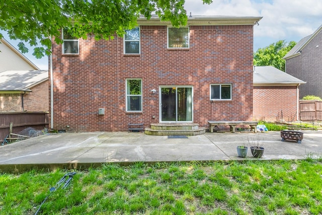 back of property with an outdoor fire pit, a patio area, entry steps, and brick siding
