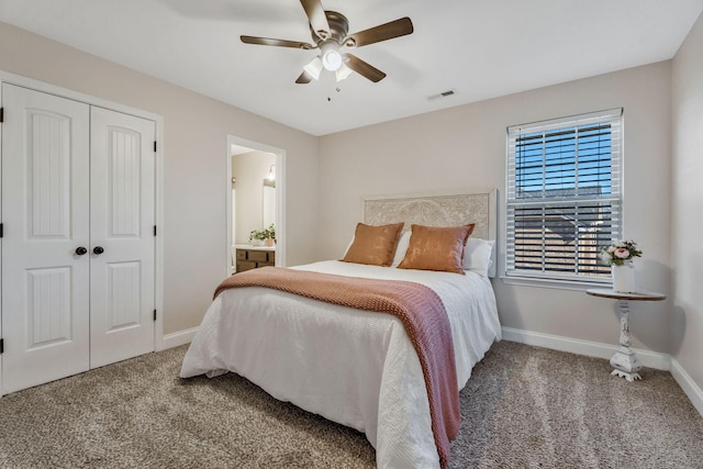 carpeted bedroom with a closet, connected bathroom, ceiling fan, baseboards, and visible vents