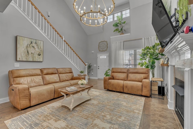 living area featuring stairway, a wealth of natural light, baseboards, and a high ceiling