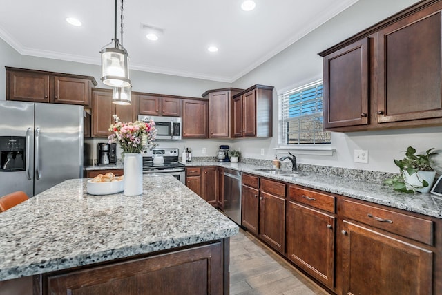 kitchen featuring stainless steel appliances, a center island, a sink, and light stone counters