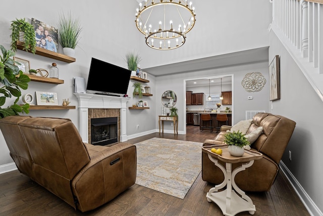 living area with baseboards, a high ceiling, dark wood-style flooring, and a fireplace