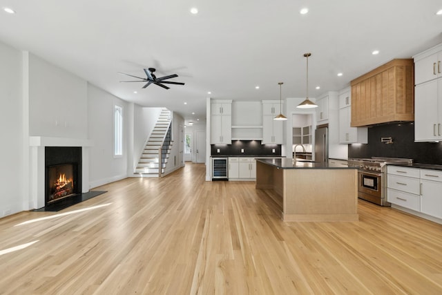 kitchen featuring open shelves, dark countertops, premium appliances, and wine cooler