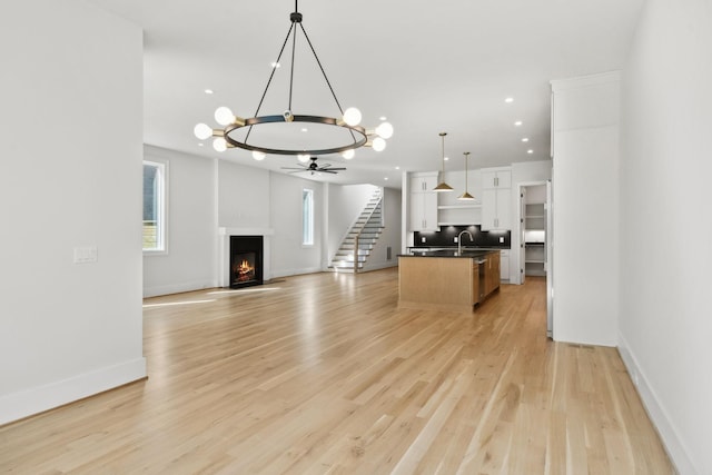 kitchen featuring dark countertops, open floor plan, white cabinets, and a healthy amount of sunlight