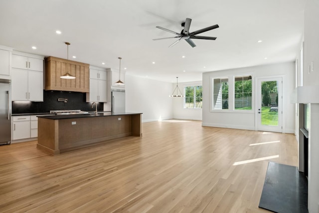 kitchen featuring recessed lighting, dark countertops, open floor plan, and high end refrigerator