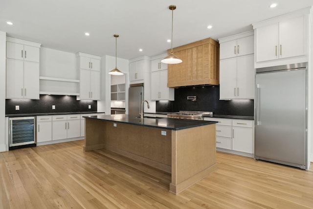 kitchen featuring wine cooler, open shelves, dark countertops, stainless steel built in fridge, and decorative backsplash