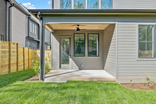 doorway to property featuring a patio area, fence, and a yard