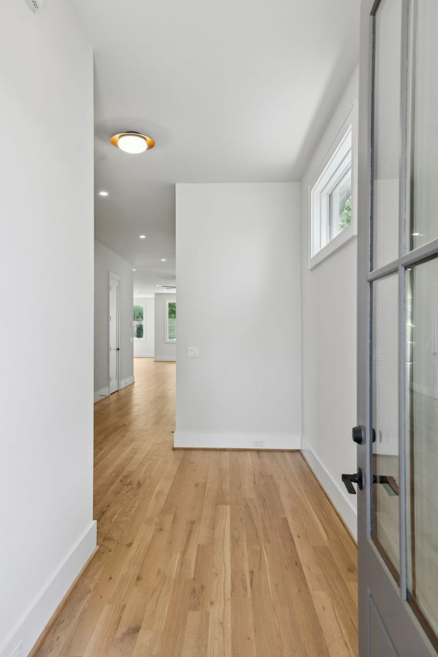 unfurnished room featuring recessed lighting, light wood-type flooring, and baseboards