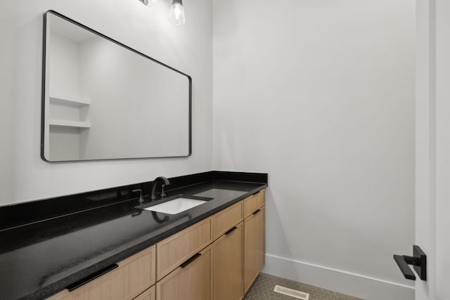 bathroom featuring baseboards, visible vents, and vanity