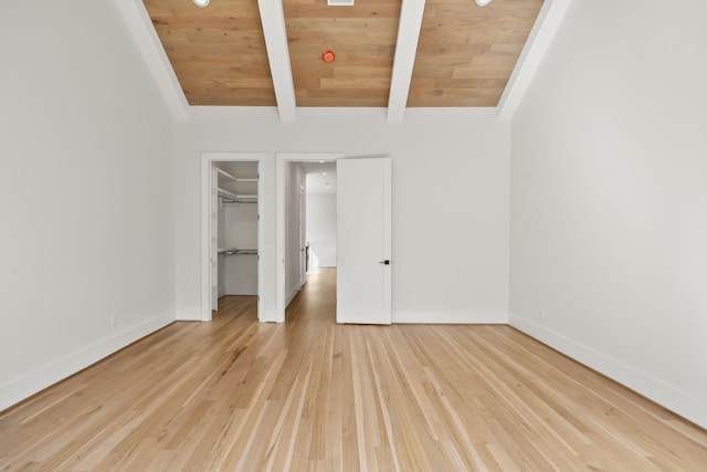 unfurnished bedroom featuring light wood finished floors, baseboards, vaulted ceiling with beams, and wooden ceiling