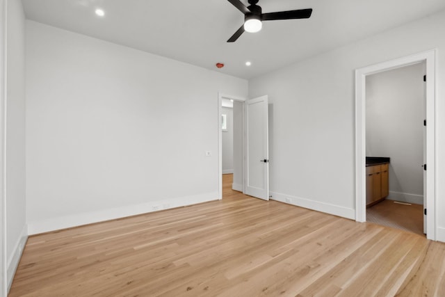 unfurnished bedroom with recessed lighting, wood finished floors, baseboards, and ensuite bathroom