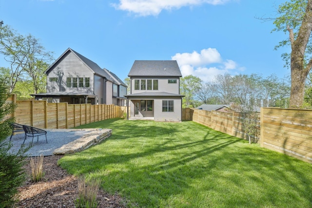 back of house featuring a yard and a fenced backyard