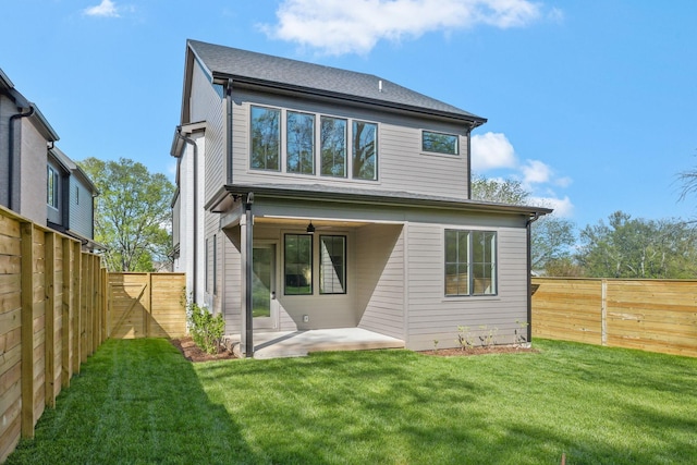 rear view of property with a yard, a fenced backyard, and a patio