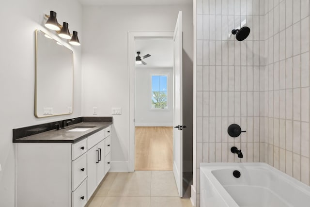 full bathroom featuring a ceiling fan, tile patterned floors, vanity, baseboards, and shower / bathtub combination